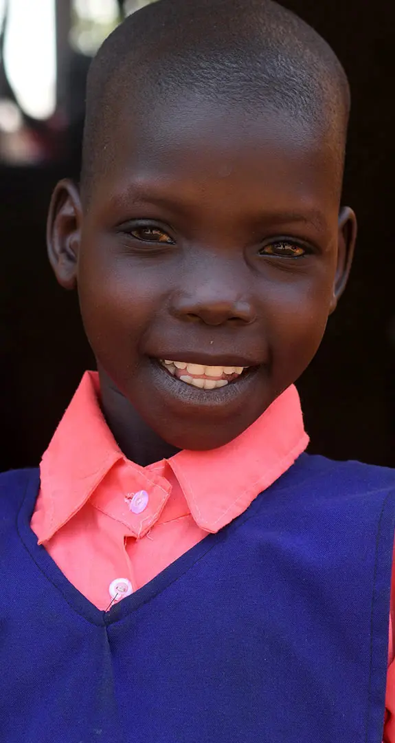 A girl in her school uniform smiling at the camera