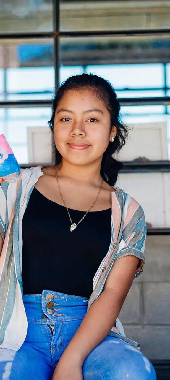 Dalila, 15, holding a dignity kit distributed by Plan International