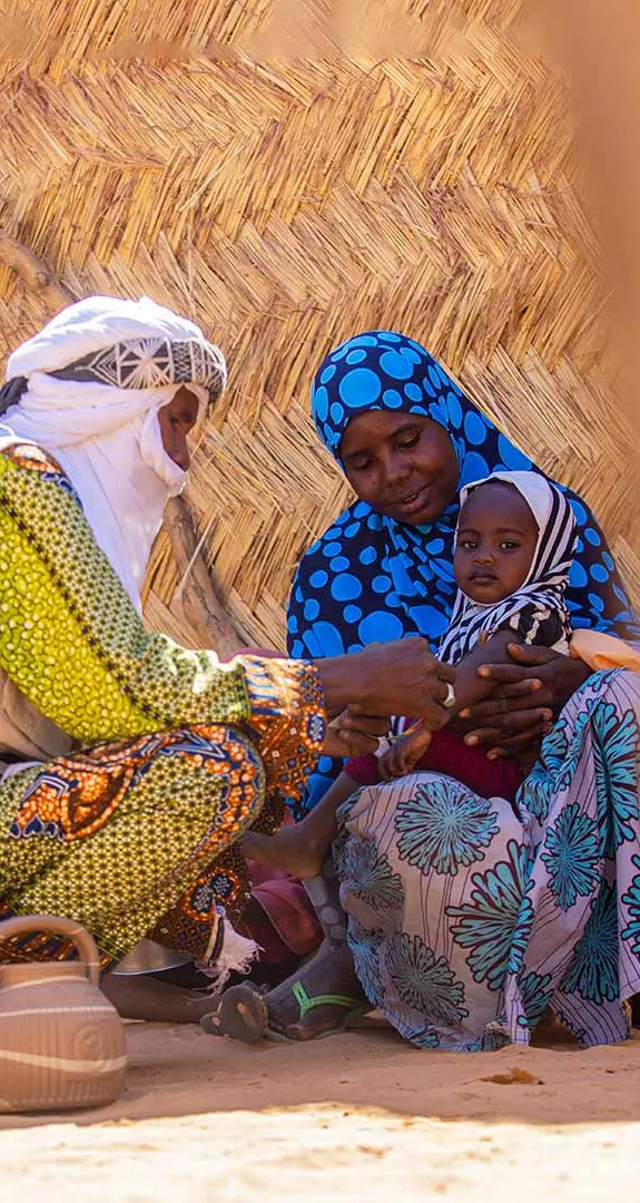 Health worker checks Balkissa's youngest child for malnutrition