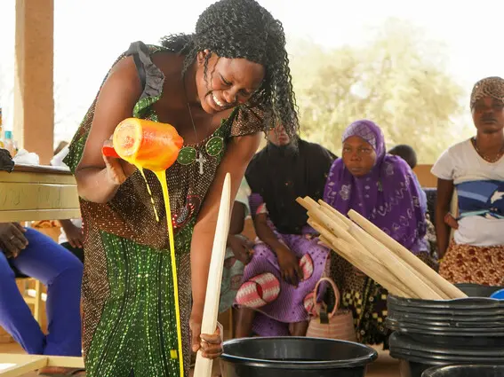 Bernadette demonstrates how to make liquid soap to young women in Burkina Faso.