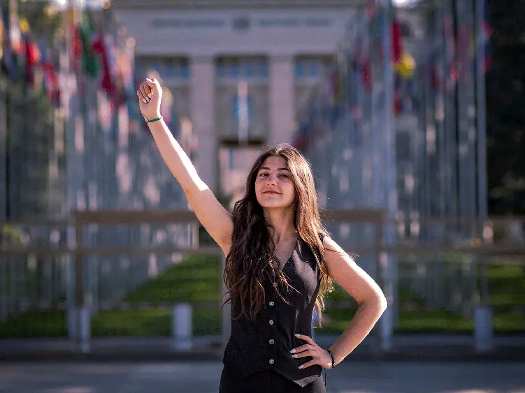 Lynne, 18, raising a clenched fist in solidarity whilst looking at the camera