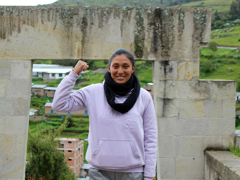 Sonia standing outside with arm raised in strength pose